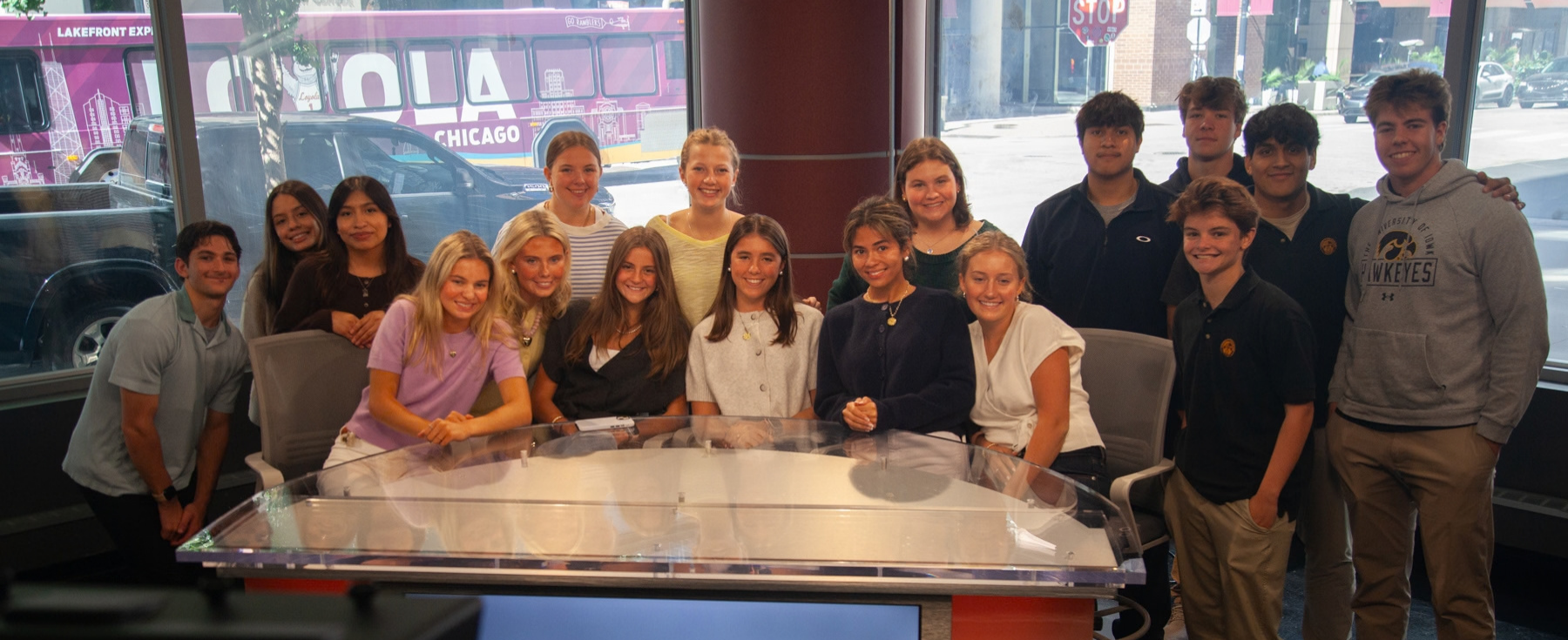 Loyola Academy students gather around the anchor desk